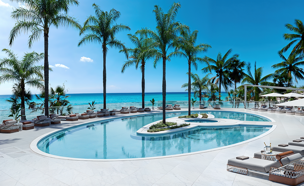 The oceanfront resort-style pool deck and spa at Bentley Residences Miami